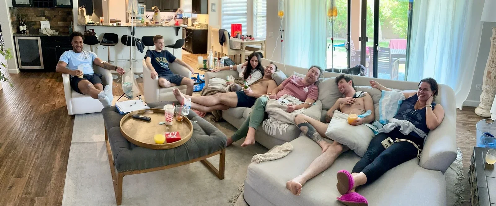A living room of friends stretched across the sofas of a Phoenix home, each on a drip, stands standing between them