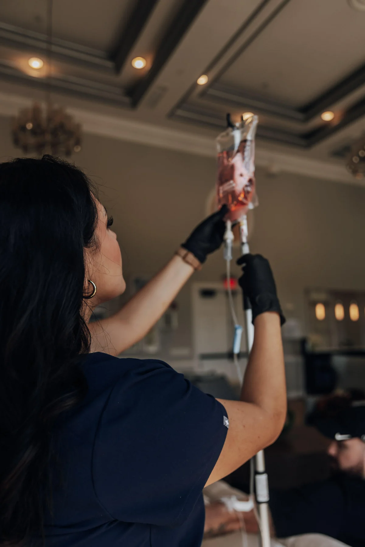 Camila Sandoval adjusting an IV bag on its stand during a visit