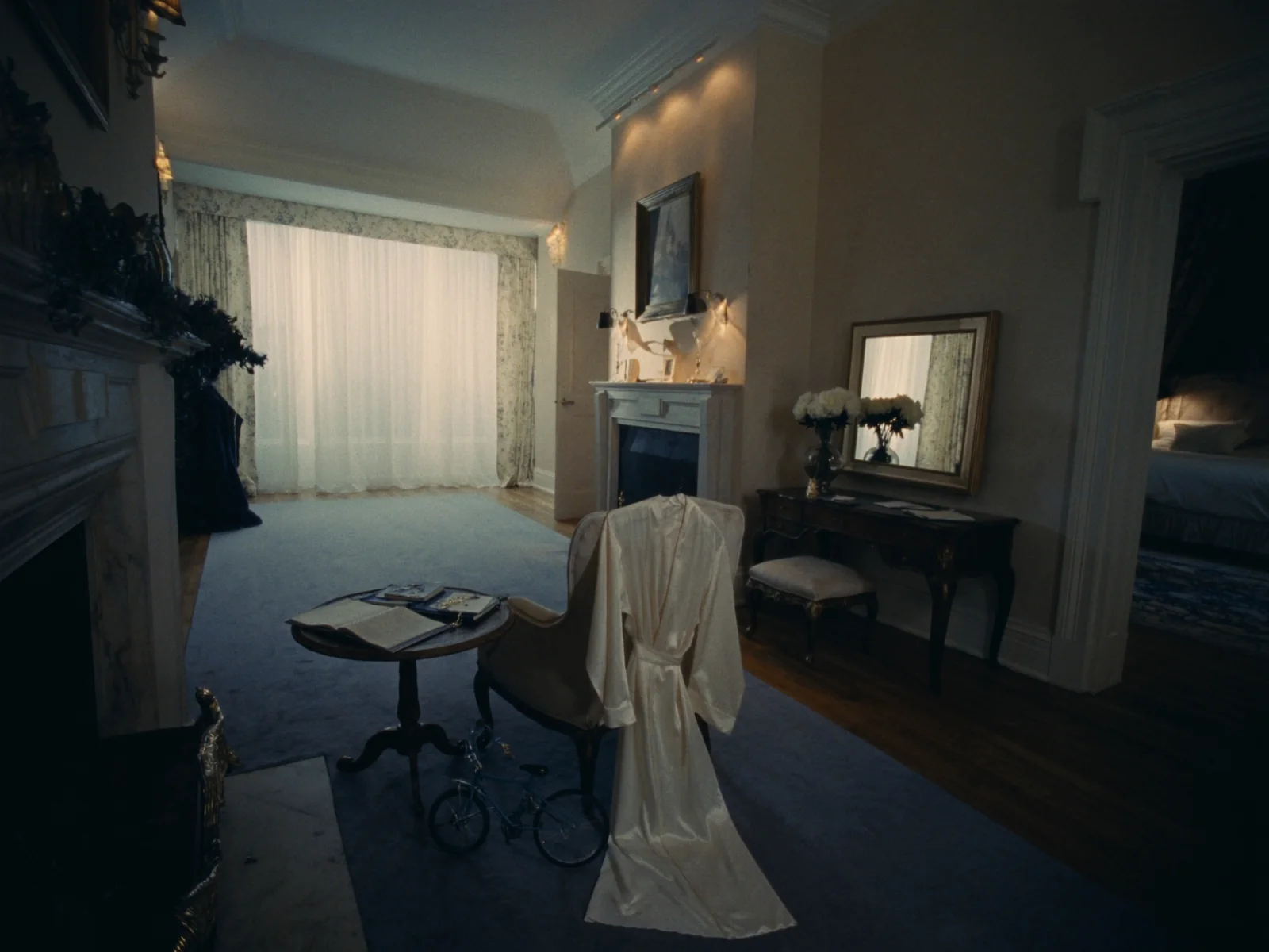 A bridal suite on the morning of a wedding: a silk robe over a chair, a dressing table and white peonies in soft daylight